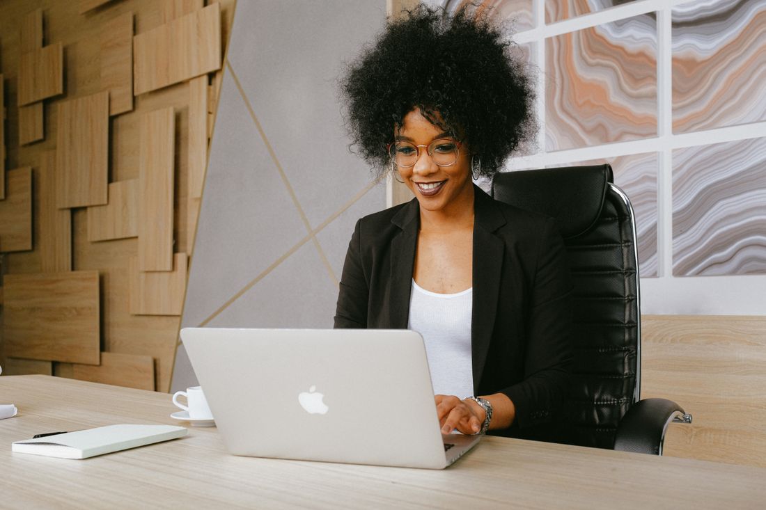 A young professional smiling as she works at her laptop